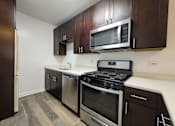 Thumbnail 3 of 15 - a kitchen with stainless steel appliances and wooden cabinets