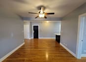 Thumbnail 14 of 15 - a empty living room with a ceiling fan and wood floors