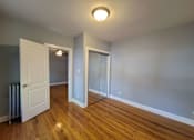 Thumbnail 13 of 15 - an empty living room with wood flooring and a door to a closet