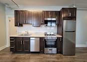 Thumbnail 7 of 21 - a kitchen with wooden cabinets and stainless steel appliances