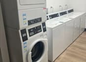 Thumbnail 12 of 18 - A row of washing machines in a laundromat.