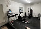 Thumbnail 13 of 18 - A treadmill is in a room with a mirror and a weight machine.