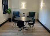 Thumbnail 16 of 18 - A room with a round table and chairs.
