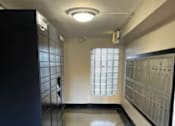 Thumbnail 11 of 18 - A hallway with a purple carpet and a black filing cabinet on the left.