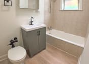 Thumbnail 15 of 17 - A white toilet sits next to a sink in a bathroom.