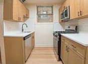 Thumbnail 12 of 17 - A kitchen with wooden cabinets and stainless steel appliances.