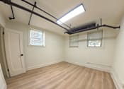 Thumbnail 16 of 17 - A room with wooden flooring and a skylight.