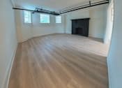 Thumbnail 14 of 17 - A room with wooden flooring and a fireplace.