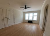 Thumbnail 6 of 13 - A room with wooden flooring and a ceiling fan.