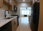 Thumbnail 3 of 13 - A kitchen with black appliances and wooden cabinets.