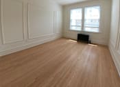 Thumbnail 10 of 13 - A room with a ceiling fan and wood flooring.