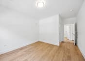 Thumbnail 56 of 60 - A room with wooden floors and white walls.