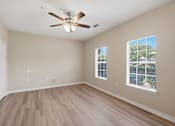 Thumbnail 24 of 34 - A room with a ceiling fan and two windows.