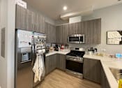 Thumbnail 25 of 45 - A modern kitchen with a refrigerator, oven, and microwave.