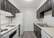 Thumbnail 28 of 37 - A kitchen with white appliances and dark wood cabinets.