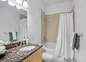 Thumbnail 24 of 46 - A bathroom with a sink, toilet, and bathtub.