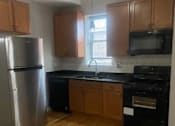 Thumbnail 10 of 14 - a kitchen with wooden floors and a stainless steel refrigerator