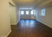 Thumbnail 9 of 14 - an empty living room with wooden floors and a window