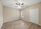 Thumbnail 26 of 34 - A room with a ceiling fan and a door.