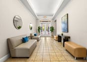 Thumbnail 51 of 71 - A hallway with beige couches and a round mirror on the wall.