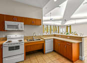 Thumbnail 53 of 71 - A kitchen with a white stove and a white microwave.