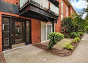 Thumbnail 20 of 31 - A red brick building with a black door and windows.