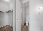 Thumbnail 32 of 37 - A white bathroom with a toilet and a walk-in closet.
