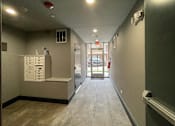 Thumbnail 30 of 45 - A long hallway with a white cabinet on the left and a door on the right.