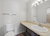 Thumbnail 33 of 37 - A white toilet sits next to a sink in a bathroom.