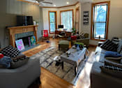 Thumbnail 2 of 13 - A living room with a fireplace and a television.