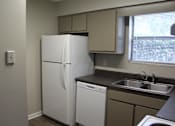 Thumbnail 20 of 24 - A white refrigerator is in a kitchen next to a dishwasher and a sink.