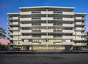 Thumbnail 53 of 54 - A large white building with many windows and balconies.