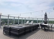 Thumbnail 51 of 54 - A deck with a table and chairs overlooking a cityscape.
