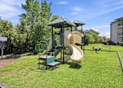 Thumbnail 32 of 34 - A playground with a green slide and a yellow slide.