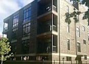 Thumbnail 33 of 45 - A modern brick building with a balcony on the second floor.