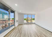 Thumbnail 37 of 54 - A room with a large window and a wooden floor.