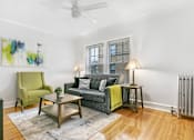 Thumbnail 9 of 15 - a living room with a couch and a chair and a ceiling fan
