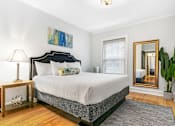 Thumbnail 8 of 15 - a bedroom with a bed and a mirror