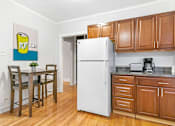 Thumbnail 10 of 15 - a kitchen with wooden cabinets and a table and a refrigerator