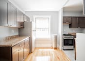 Thumbnail 4 of 15 - a kitchen with wooden cabinets and stainless steel appliances and a window