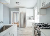 Thumbnail 5 of 15 - a white kitchen with a stove and a refrigerator