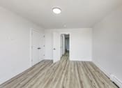 Thumbnail 48 of 54 - A long hallway with white walls and wood flooring.