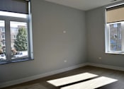 Thumbnail 37 of 45 - A room with a large window and a view of a building across the street.