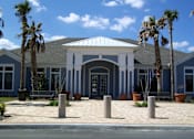 Thumbnail 36 of 44 - A building with a blue and white facade is surrounded by palm trees.