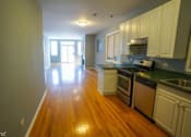 Thumbnail 1 of 14 - an empty kitchen and living room with a wood floor