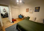 Thumbnail 13 of 25 - A bedroom with a bed, desk, and chair.