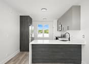 Thumbnail 4 of 27 - A modern kitchen with a large island and a view of the outdoors.