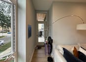 Thumbnail 5 of 45 - A living room with a white couch and a purple vacuum cleaner.