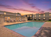 Thumbnail 5 of 37 - A swimming pool surrounded by a concrete patio and lounge chairs.
