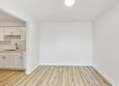 Thumbnail 49 of 54 - A kitchen with wooden floors and white walls.